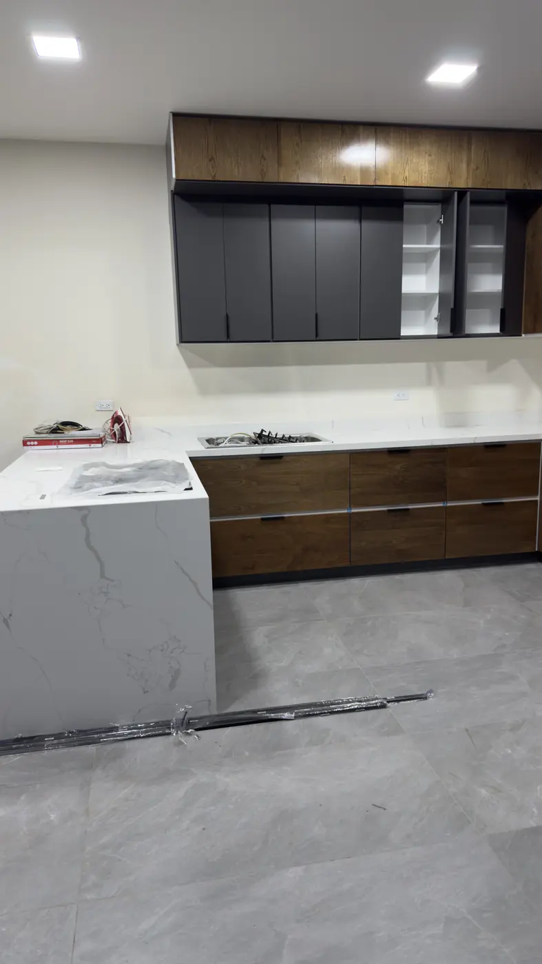 Cocina con isla con caída en cuarzo Calacatta blanco con vetas grises